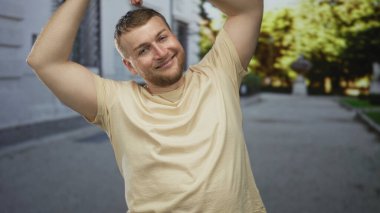 İnsanlar, elleri başının üstünde binalar ve ağaçlarla dolu bir caddede gülümserken bir kalp oluştururlar; neşeli sevgi dolu bir neşe.