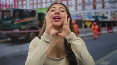 İnşaat halindeki bir binanın önünde eli kolu bağlı bağıran genç İspanyol kadın..