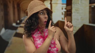 Orta yaşlı İspanyol kadın eski şehir sokaklarında parmak uçlarına dolaşır; keşif heyecanı davetiyesi.