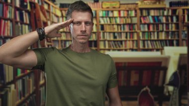Kafkasyalı genç adam kitaplıklar ve kitaplarla çevrili kütüphanede el ele selamlıyor; disiplin çalışmasına saygı.