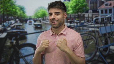 Erkekler sıkılmış yumruklarını kaldırıyor ve bisiklet ve binaların arasında kanalda gülümsüyor; sevinç zaferi kutlamaları.