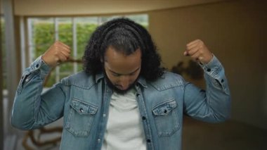 Kot ceketli İspanyol adam binanın içinde yumruk sallıyor, aşağı bakıyor, güven sorunu çözülüyor.