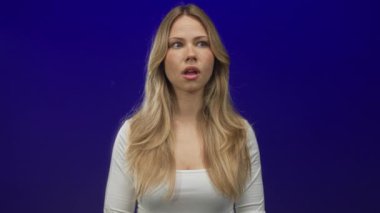 Kafkasyalı sarışın kadın stüdyo çekimlerinde beyaz bluz giyerken ağzı açık esner; yorgunluk yorgunluk yorgunluğu.