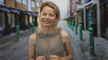 Kadın geniş bir gülümseme ve ince elleri ile renkli bir tuğla dükkan çerçeve dar bir kaldırım taşı sokakta yürürken; mutluluk.