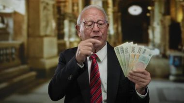 Kilise içinde Czech Koruna banknotları tutan kıdemli bir adam, dini bir ortamda iş ve zenginliği simgeliyor..