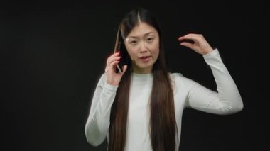 Telefondaki kadın, esmer geçmişiyle alay ederek konuşuyor. Neşeli bir ifade ve uzun saçlar sergiliyor. Günlük kıyafetlere ve iletişim hareketlerine odaklanıyor..