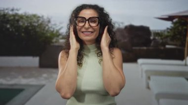 Yeşil bluz giyen ve gözlüklü bir kadın yolcu güvertesi binasında el ele tutuşuyor..