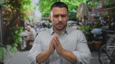 Adam kapalı restoran terasında gözleri sıkma ve bulanık kafe masalarına karşı el kaldırma; tiksinti.