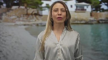 Ağaçlarla birlikte suyun yanında duran kadın.