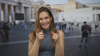 Genç beyaz kadın, Vatikan 'daki St. Peter Meydanı' ndaki bir sokakta işaret parmağıyla işaret ediyor..