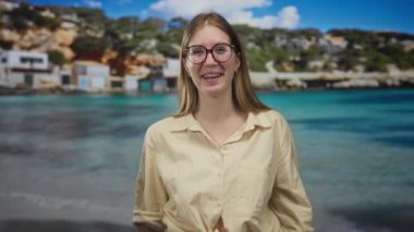 Güneşli yaz gününde sahilde elleri ile pençe hareketi yapan kadın; neşeli yaz neşesi titreşimi.