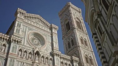 Gül pencereli katedral cephesi ve bitişik kamp kulesi, görünür mermer detaylar, binalarda yükselme; zamansız korku.