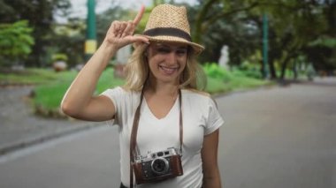 Klasik kamera formları olan bir kadın Yapraklı bir yolda parmaklarımla saman şapkalı bir kadınla anlaşırım;.