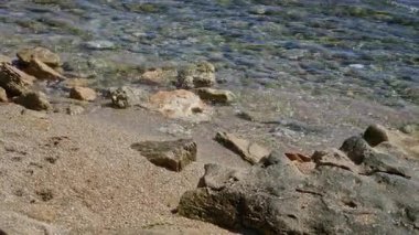 Açık deniz suyuyla güneşli Akdeniz sahilleri kayalık sahili usulca kaplıyor, sakin bir açık deniz kaçışı yaratıyor..