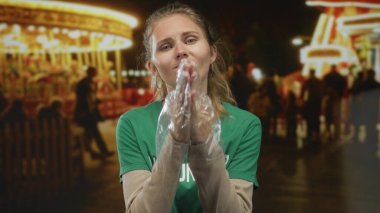 Karnavalda genç ve sarışın bir gönüllüyle el ele dua eden bir kadın..