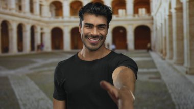 İnsan, tarihi bina avlusunda el sıkışmak için sağ elini uzatıyor. Sabah güneşinde yıkanan avluda. Arkadaşlık..