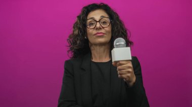 Orta yaşlı İspanyol muhabir stüdyoda mikrofonu tutarken kafaya dokunuyor..