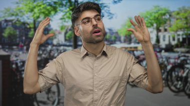 Şehrin caddesinde, bisiklet parkının yanında el kol hareketi yapan genç bir İspanyol, coşkulu bir ifade..