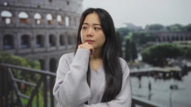 İkonik Roma Kolezyumu 'nun önünde duran kadın İtalya' nın tarihi mekanında sakin bir açık hava atmosferiyle merak ve tefekkür yayıyor..