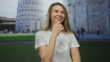 Pisa kulesine yaslanmış gülümseyen bir kadın, İtalya 'da kaygısız enerjiyle neşeli bir açık hava seyahati anını yakalıyor..