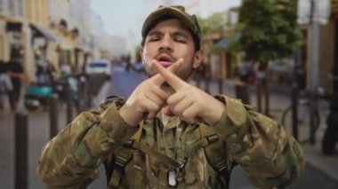 Köstebek künyesi takan genç İspanyol asker şehrin hareketli caddesinde işaret parmağıyla işaret diliyle işaret diliyle işaret diliyle işaret diliyordu..