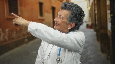Gri saçlı ve steteskoplu kıdemli kadın doktor, eski bir şehir caddesinde dikilirken, hareketli bir şehirde güven ve bilgelik yayıyor..