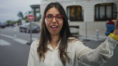 Genç İspanyol kadın binanın dışındaki hareketli bir caddeye öpüşme jesti yolluyor; şakacı bir flört..