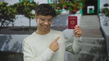 Şehir caddesinde Yunan pasaportu taşıyan gözlüklü genç İspanyol adam; gurur özgürlük fırsatı yolculuğu.