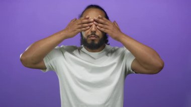 Stüdyoda gözleri kapayan ve görünen sakallı bir adam beyaz tişört giyiyor. Sürpriz kutlama heyecanı..