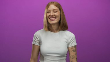 Genç bir kadın parlak bir fotoğraf stüdyosu ortamında komik bir yüz için dudaklarını büzüyor..