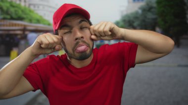 İspanyol kurye, hediyelik eşya tezgahlarıyla kırmızı şapkalı ve tişörtlü yanaklarını dışarı çıkarıyor..