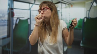 Kadın, yeşil koltuklar ve pencere manzaralı bir sokak otobüsünün içinde anahtarlık tutarken ve kıt kanaat nefes alırken yumruk yumruğa öksürüyor; hastalıklı bir endişe.