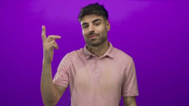 Sakallı genç İspanyol adam gülümsüyor ve parmağını yukarı kaldırıyor..