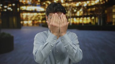 Gece vakti sokak pencereleri ile aydınlatılan sokakta avuçlarıyla el kaldıran bir adam. Sürpriz..