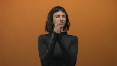 Stüdyoda çıplak elle bastıran siyah spor giyim giymiş genç İspanyol kadın. Huzur farkındalığı..