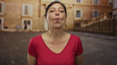 Tarihi binanın önündeki güneşli eski kasaba sokağında çıplak omuzlarıyla gülümseyen kadın, mutluluk..