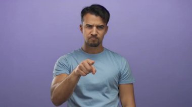 Genç İspanyol asıllı bir adam, soyutlanmış mor bir arka planda gösterişsiz bir jest yapıyor. Hislerini ve tutumunu canlı ve ilgi çekici bir şekilde ifade ediyor..