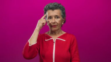 Son sınıf öğrencisi, gri saçlı, kırmızı saçlı, düşünceli, parlak pembe arka planda başını gösteren.