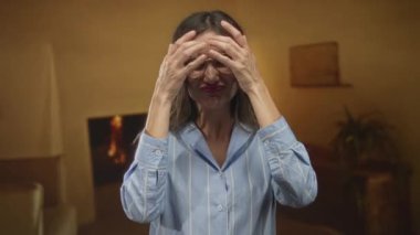 Gözlüklü ve mavi gömlekli kadın bina içinde barış işareti gösterirken el ele tutuşuyor; dayanışma sevincinin sıcaklığı.