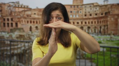 Sarı tişört giyen kadın, Roma harabeleriyle dolu bir binada el ele tutuşuyor. Sabır..