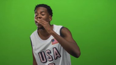 ABD basketbol forması giyen bir adam stüdyoda kıt kanaat arıyor..