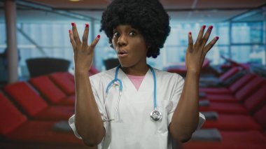 Steteskoplu beyaz önlük giyen genç kadın doktor iki elini de havaalanında kaldırdı..