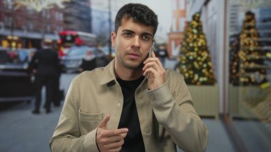 Telefonunu tutan adam, şehirde cep telefonu olan genç bir İspanyol 'un birini araması üzerine sokakta sessizlik işareti veriyor..