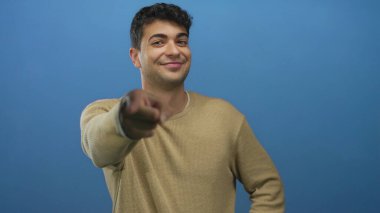 Adam arka planda genç modelin İspanyol zarafetini göstermek için parmağını uzatıyor. Stüdyoda erkek figürü olan mavi renkli bir arka plana karşı..