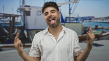 Kaya boynuzlarını deniz kıyısında güneşli bir caddede teknenin önünde çıplak elle hareket ettirir..