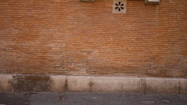 Görünür havan hatları, çipler ve ince lekeler, keskin yüzey ayrıntıları ile aşınmış turuncu tuğla duvar dokusu; arka plan telif alanı sakin.