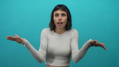 Genç İspanyol kadın stüdyoda gözlerini ovuştururken göz çukurlarını turkuaz bir duvara bastırıyor..