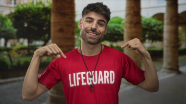 Kırmızı tişört giyen ve boynunda ıslık çalan cankurtaran avluda parmak göğse, onur görevinde..