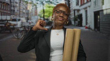 Enerjik Afro-Amerikan kadını, şehrin kaldırım taşlı caddesinde kendine has planlar ve işaretler tutuyor..