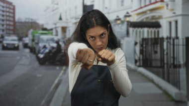 Şehir merkezinin önündeki caddede yumruk atan genç bir kadın. Kararlılık..